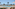 Luxury resort pool with ocean view, palm trees, and lounge chairs.