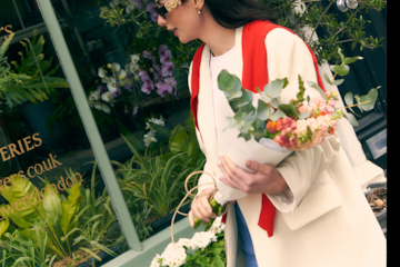 a woman holding a basket of flowers
