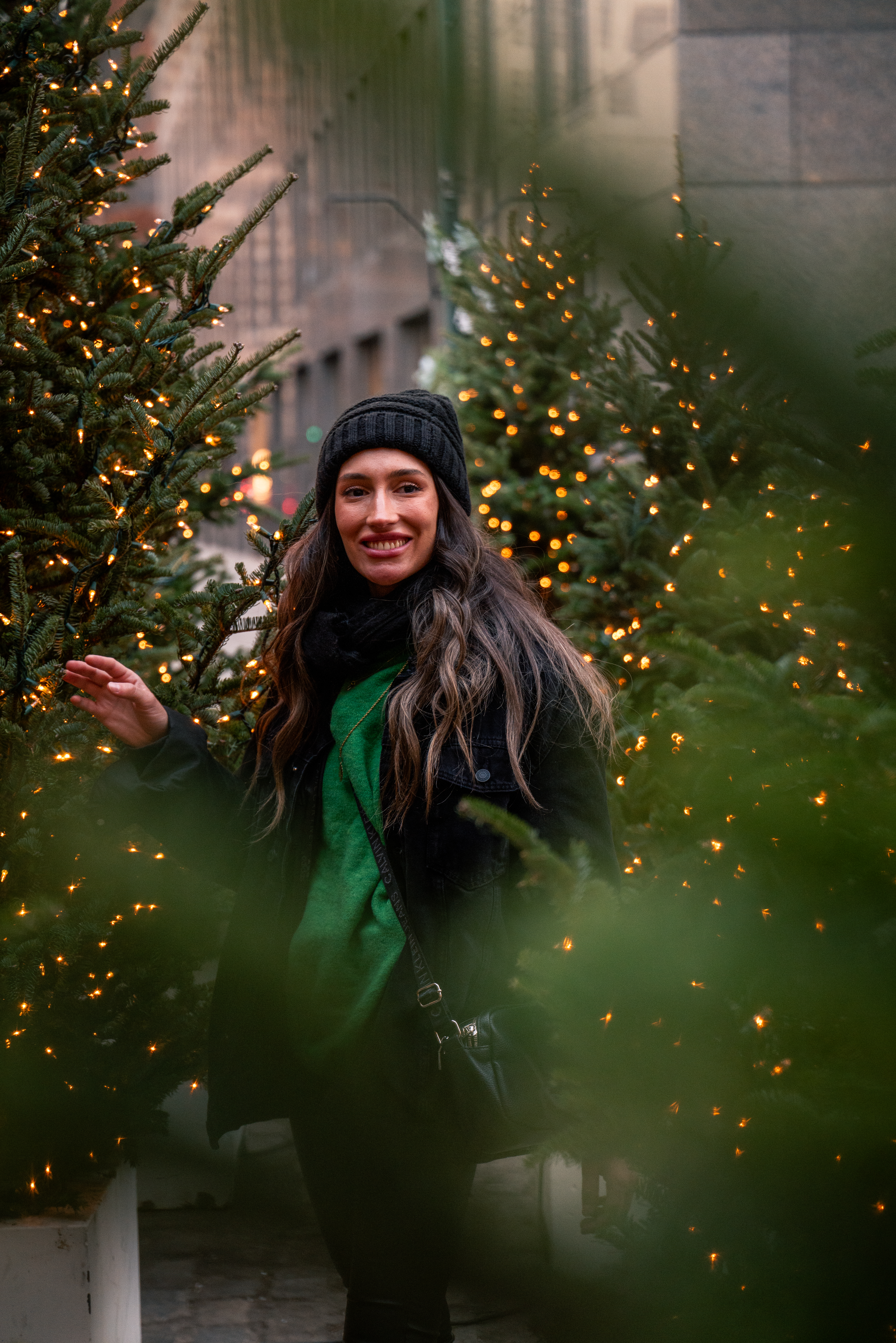 a woman standing in front of christmas trees