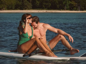 a man and woman sitting on a surfboard