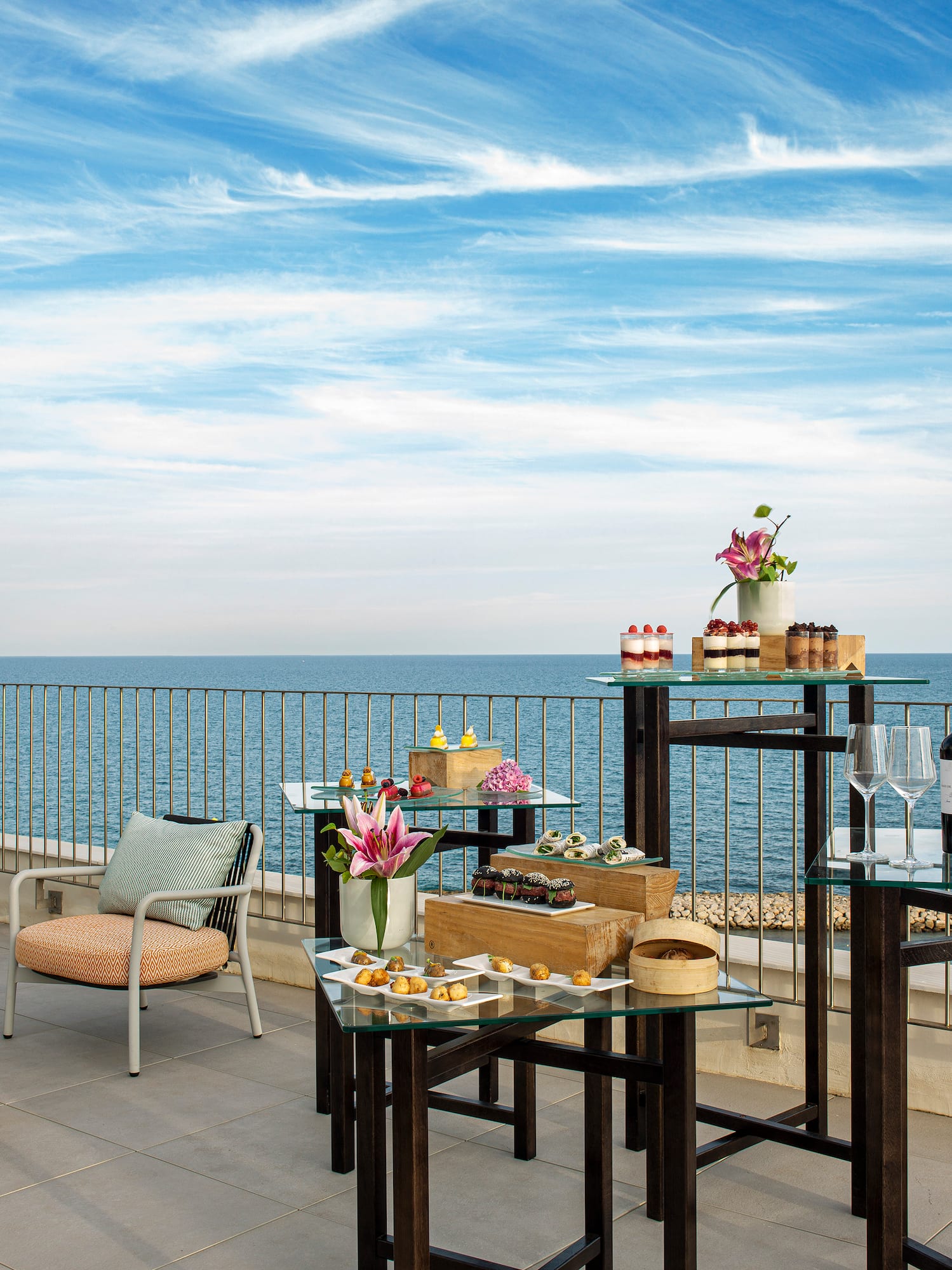 a table and chairs on a patio overlooking the ocean