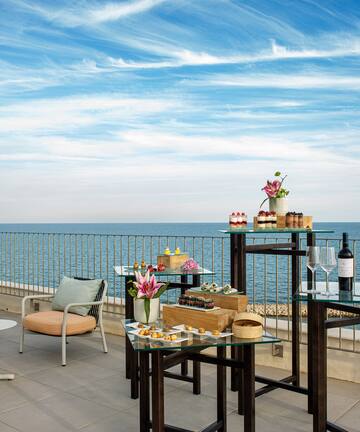 a table and chairs on a patio overlooking the ocean
