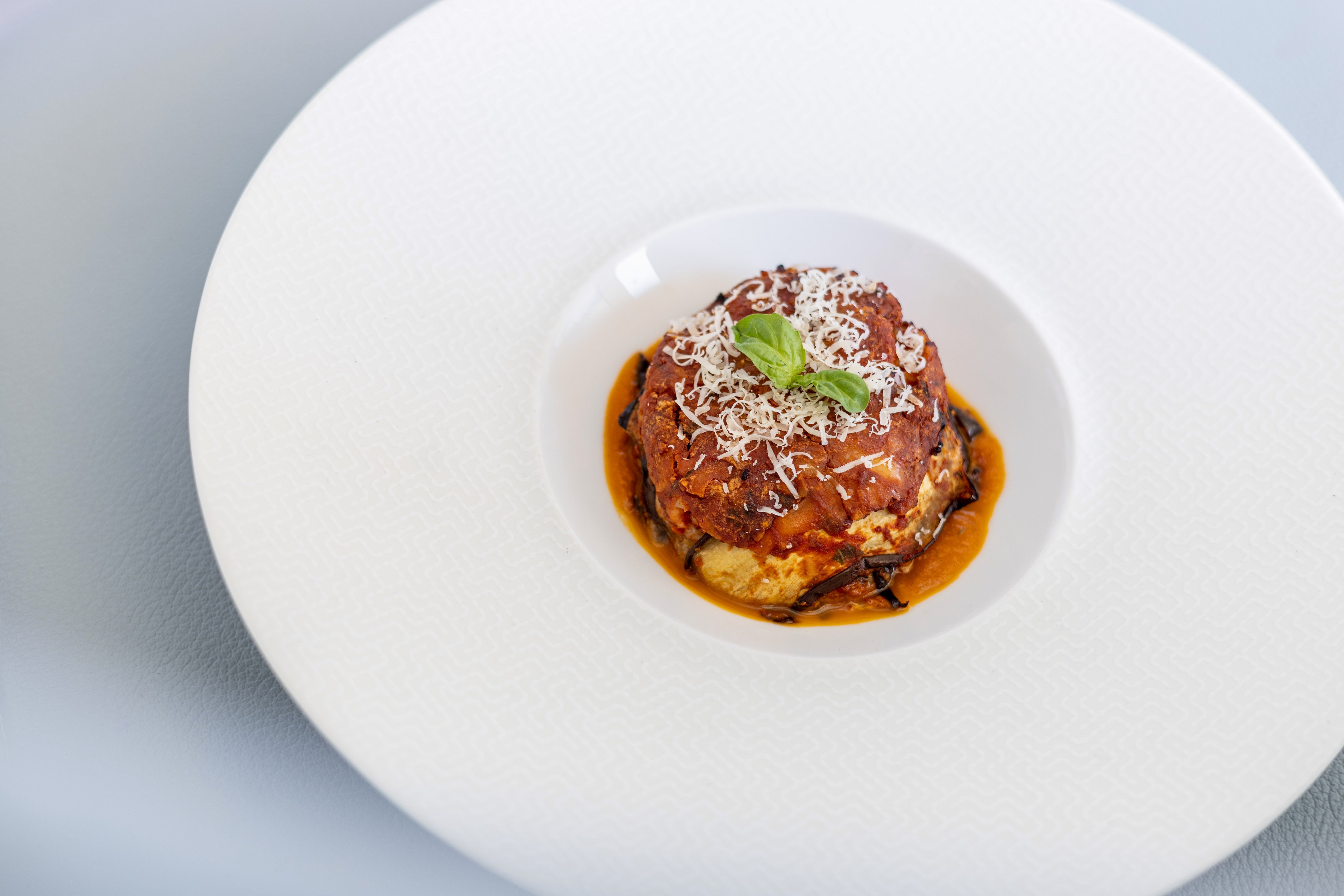 Italian eggplant parmigiana with tomato sauce, Parmesan cheese, and fresh basil.
