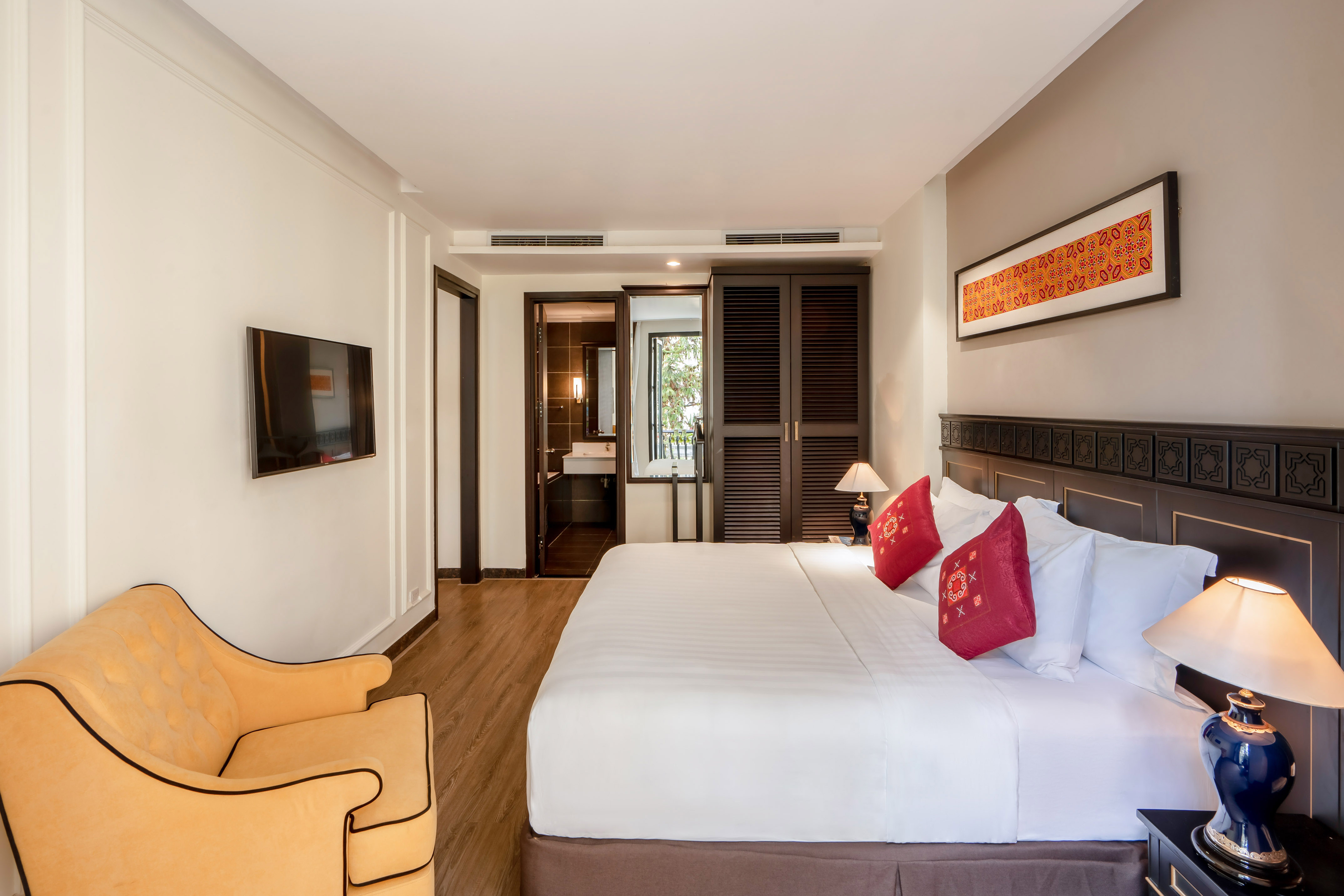 Modern hotel room with king bed, yellow armchair, TV, and elegant decor. - Executive Suite - Hotel Sapa Square Affiliated by Meliá, Sapa
