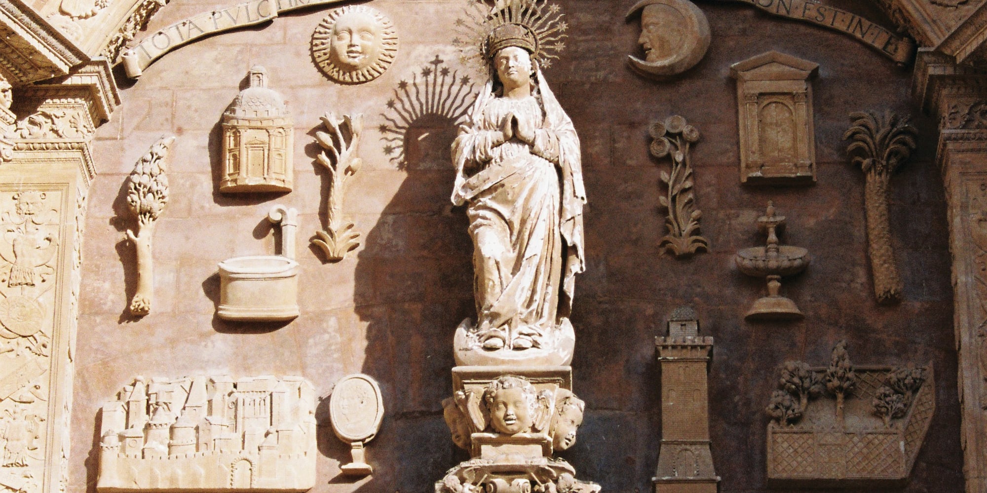 a statue of a woman in a crown on a wall