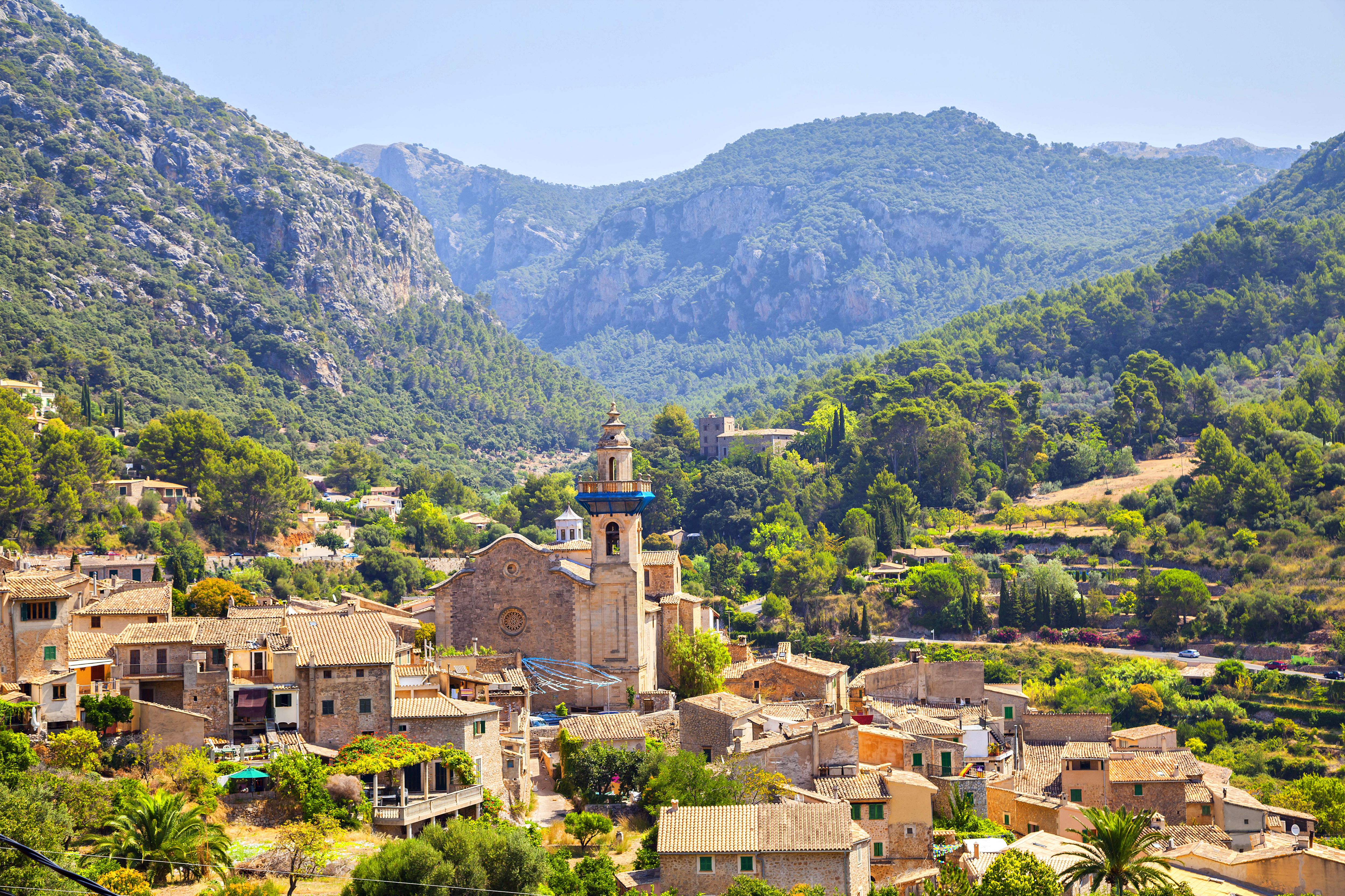 Valldemossa, Mallorca: pueblo de montaña con iglesia de cúpula azul y casas.