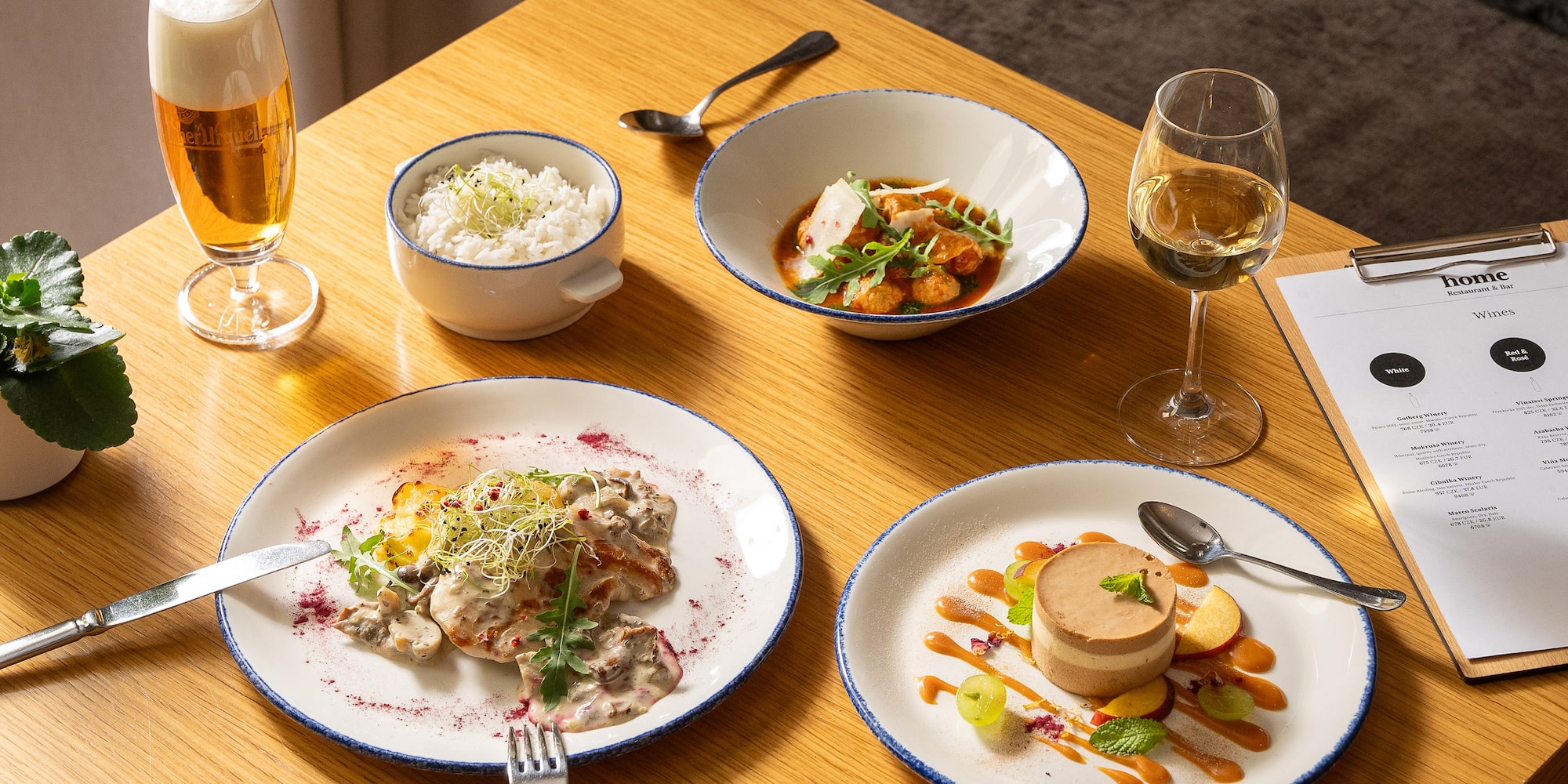 a table with plates of food and glasses of wine