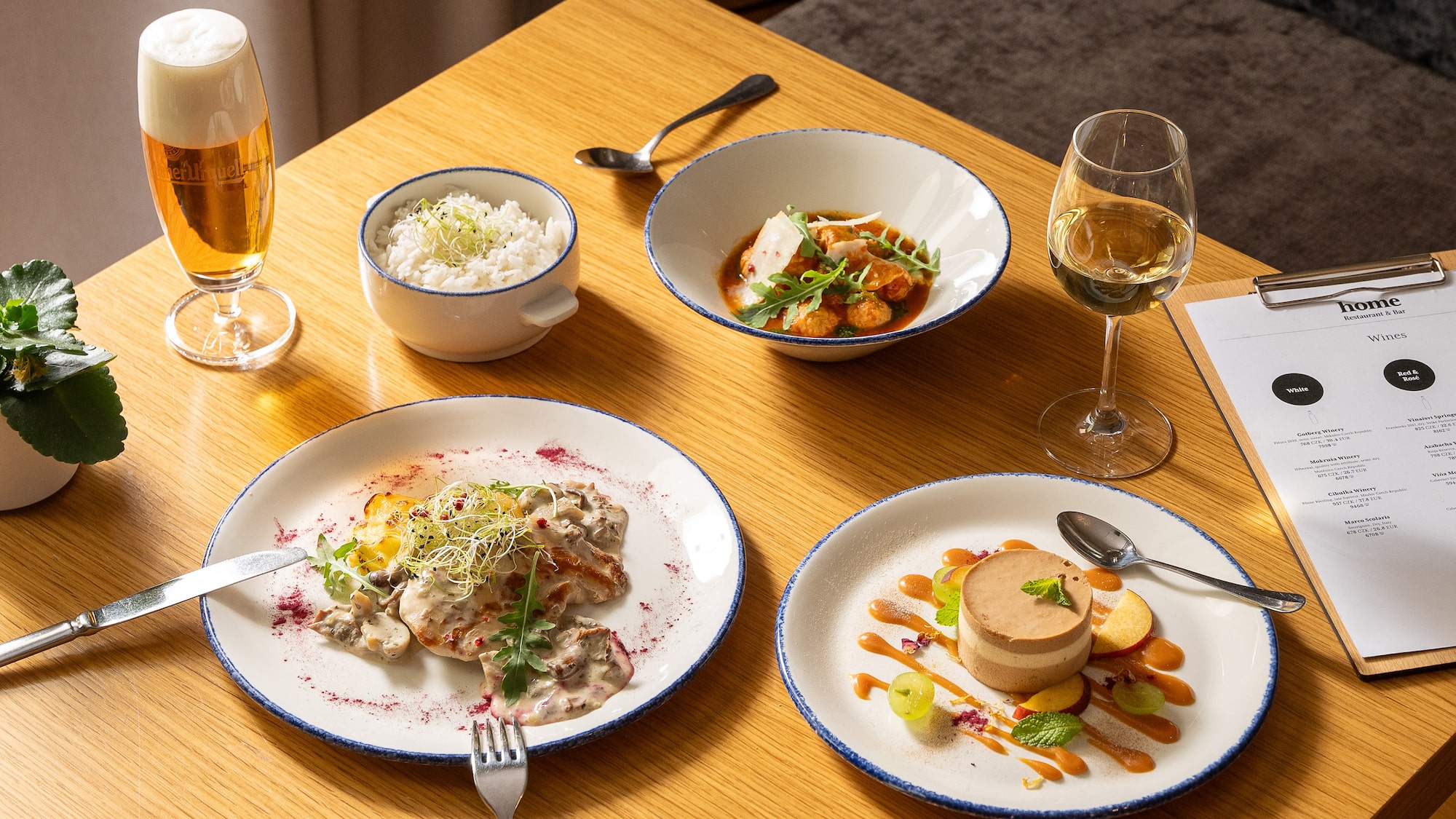 a table with plates of food and glasses of wine