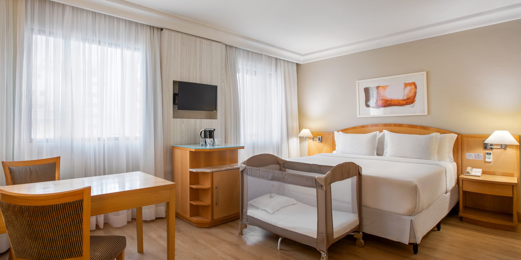 a room with a bed and a table and chairs