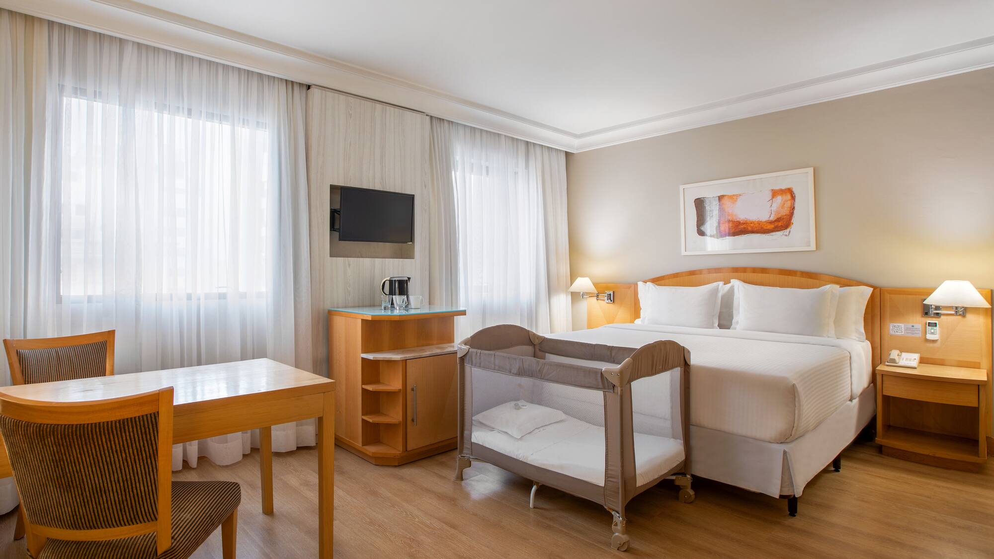 a room with a bed and a table and chairs