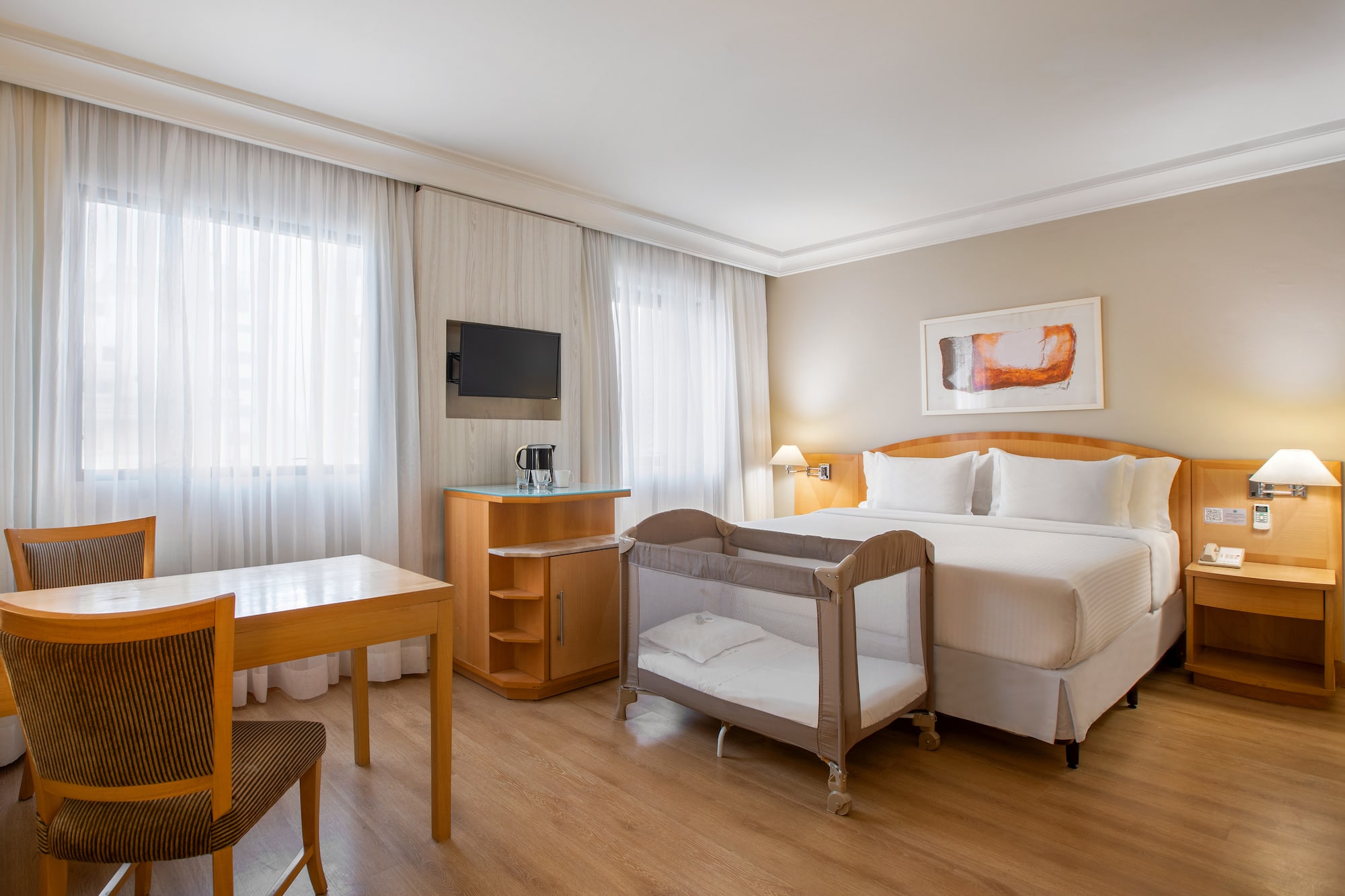 a room with a bed and a table and chairs