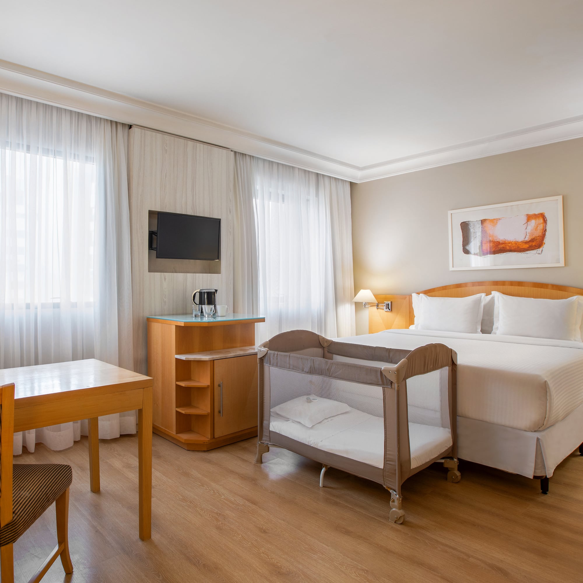 a room with a bed and a table and chairs