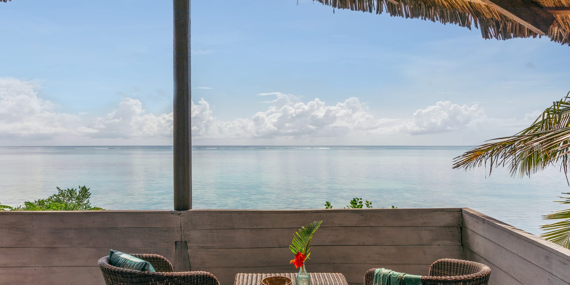 a table and chairs on a deck overlooking the ocean