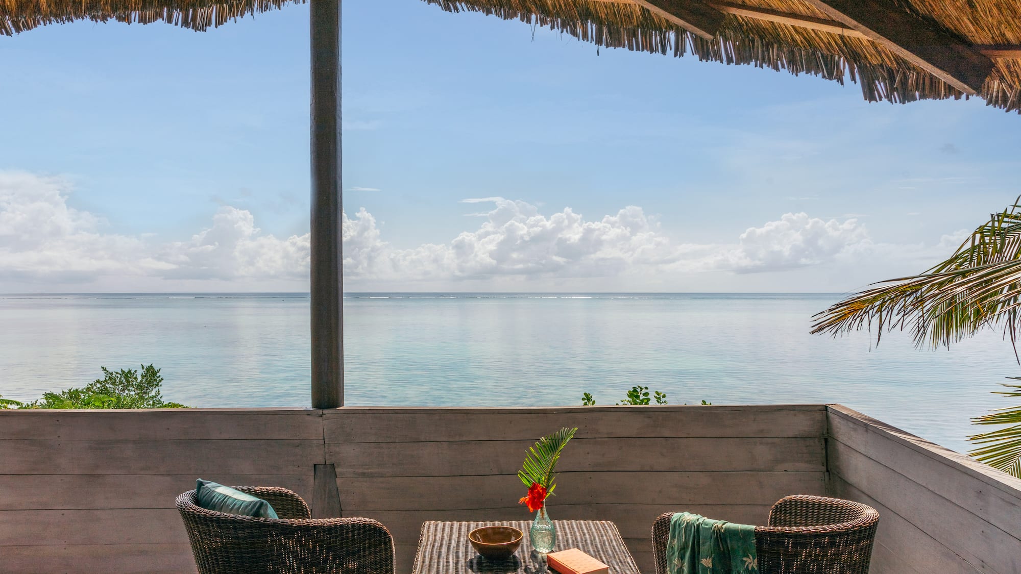 a table and chairs on a deck overlooking the ocean