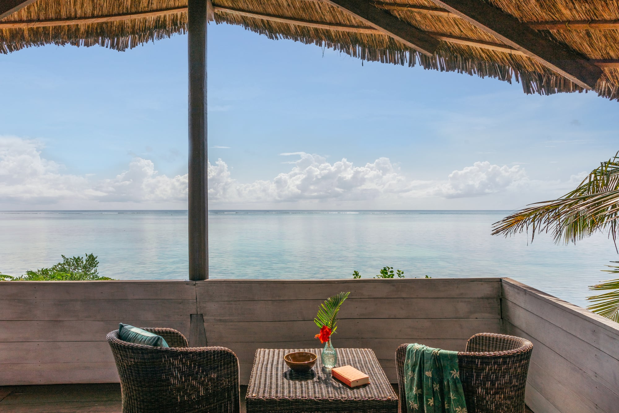 a table and chairs on a deck overlooking the ocean