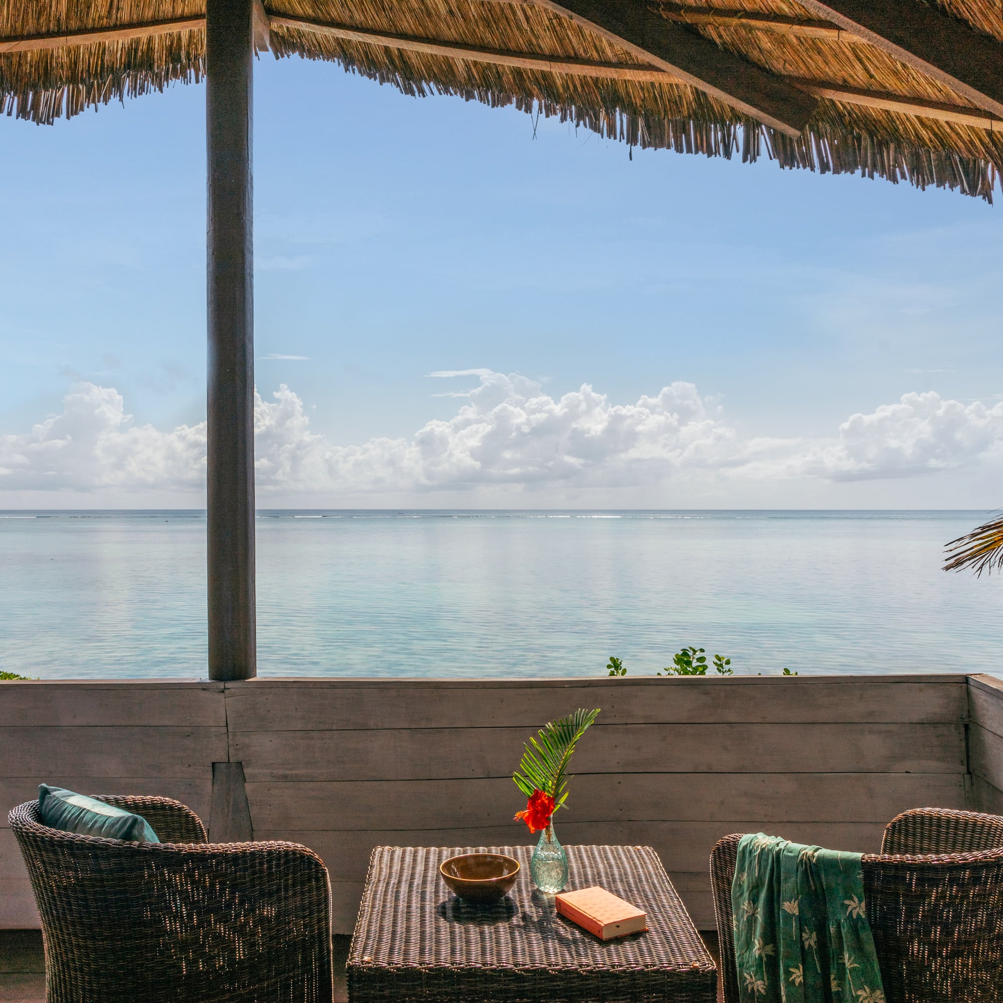 a table and chairs on a deck overlooking the ocean