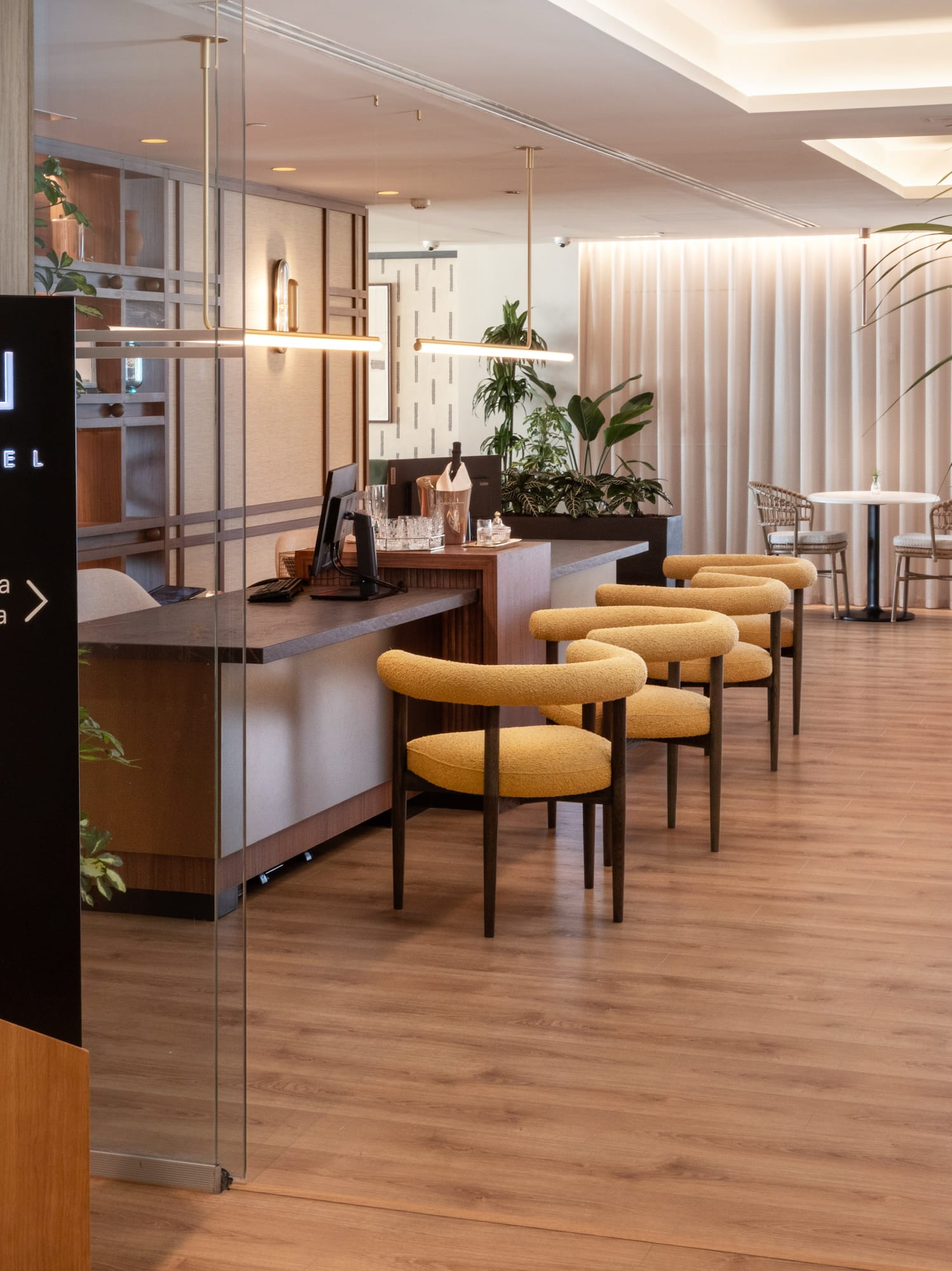 The Level exclusive area, modern reception desk, yellow chairs, wood floor.