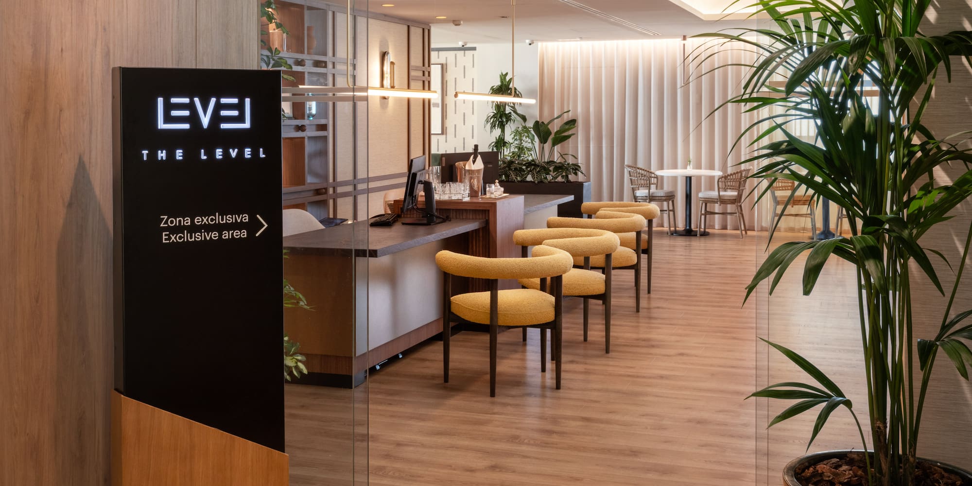 The Level exclusive hotel lounge with modern yellow chairs and reception area.