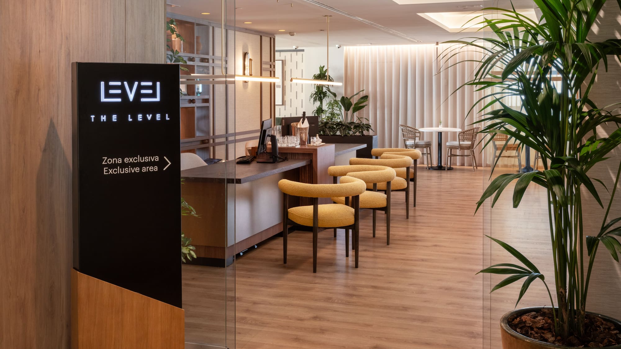 The Level exclusive hotel lounge with modern yellow chairs and reception area.