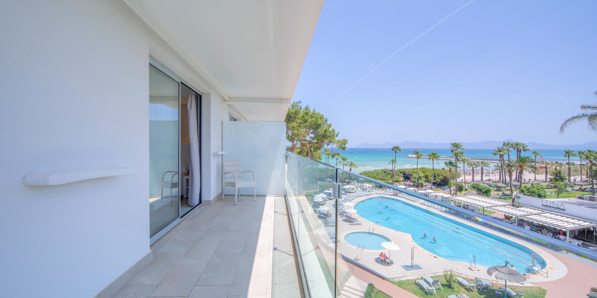 a balcony with a pool and a beach
