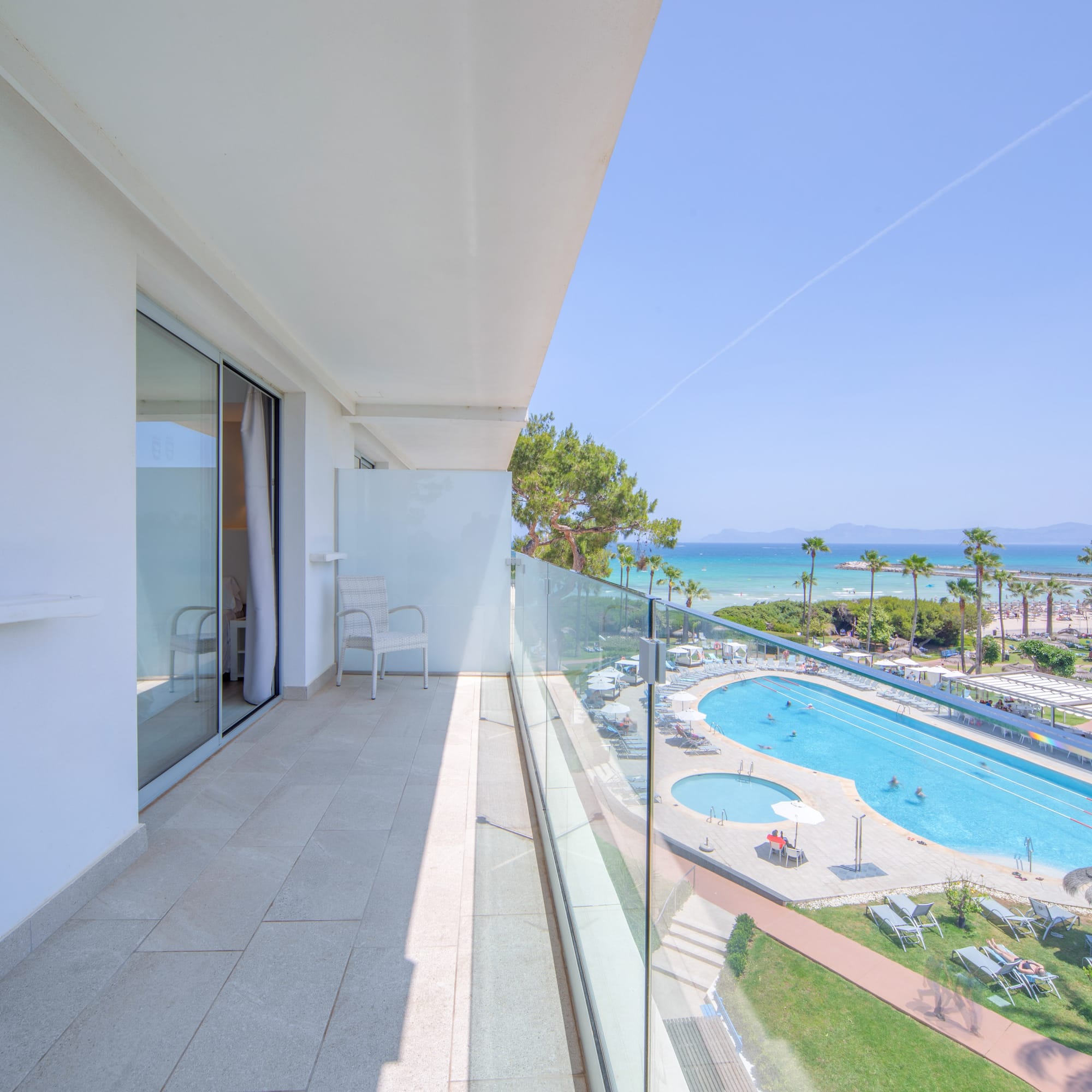 a balcony with a pool and a beach