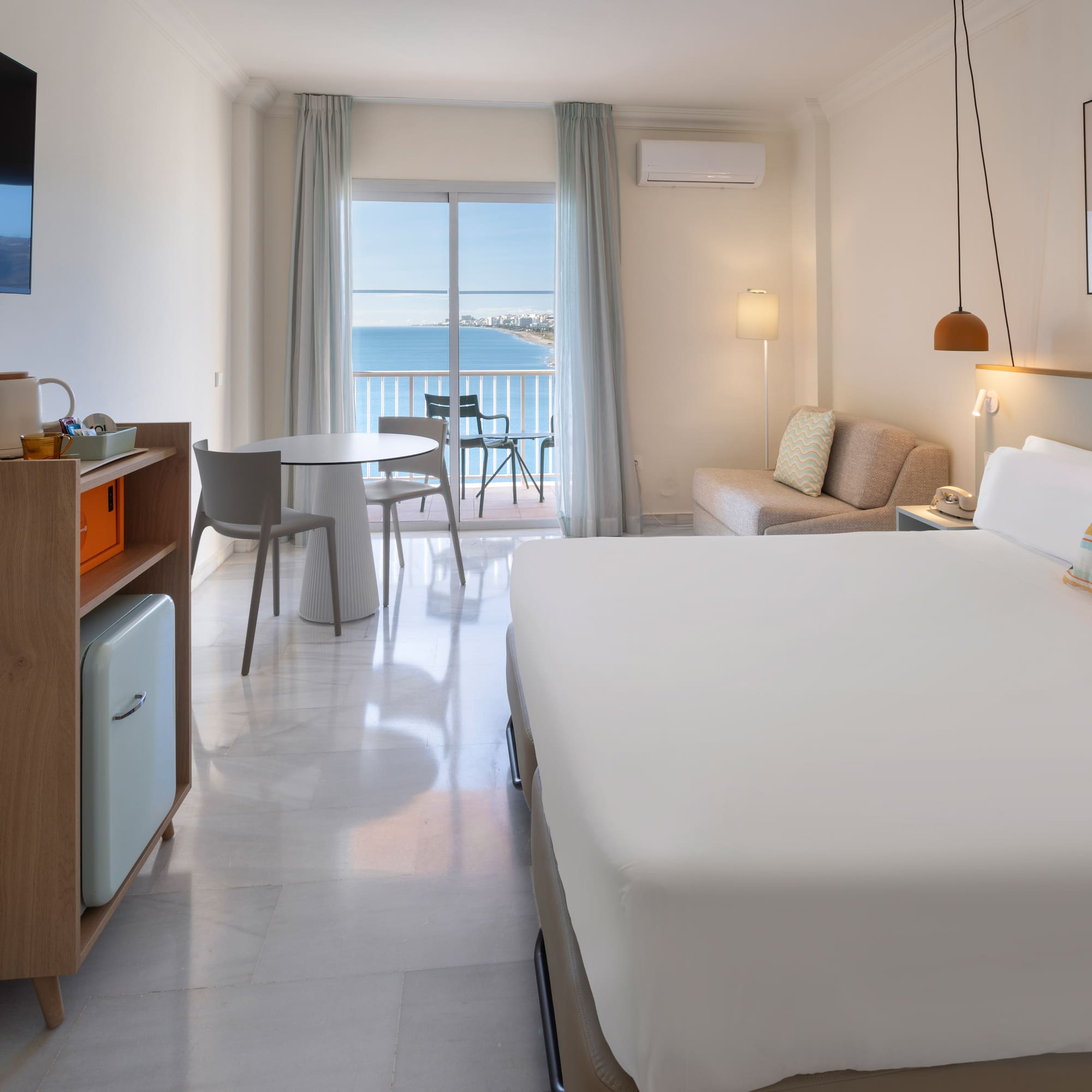 a room with a bed and a table and chairs