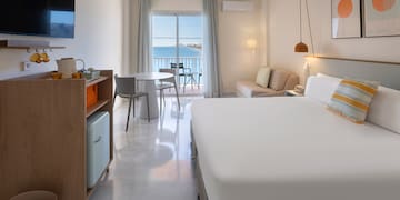 a room with a bed and a table and chairs