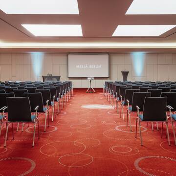 a room with rows of chairs and a projector screen
