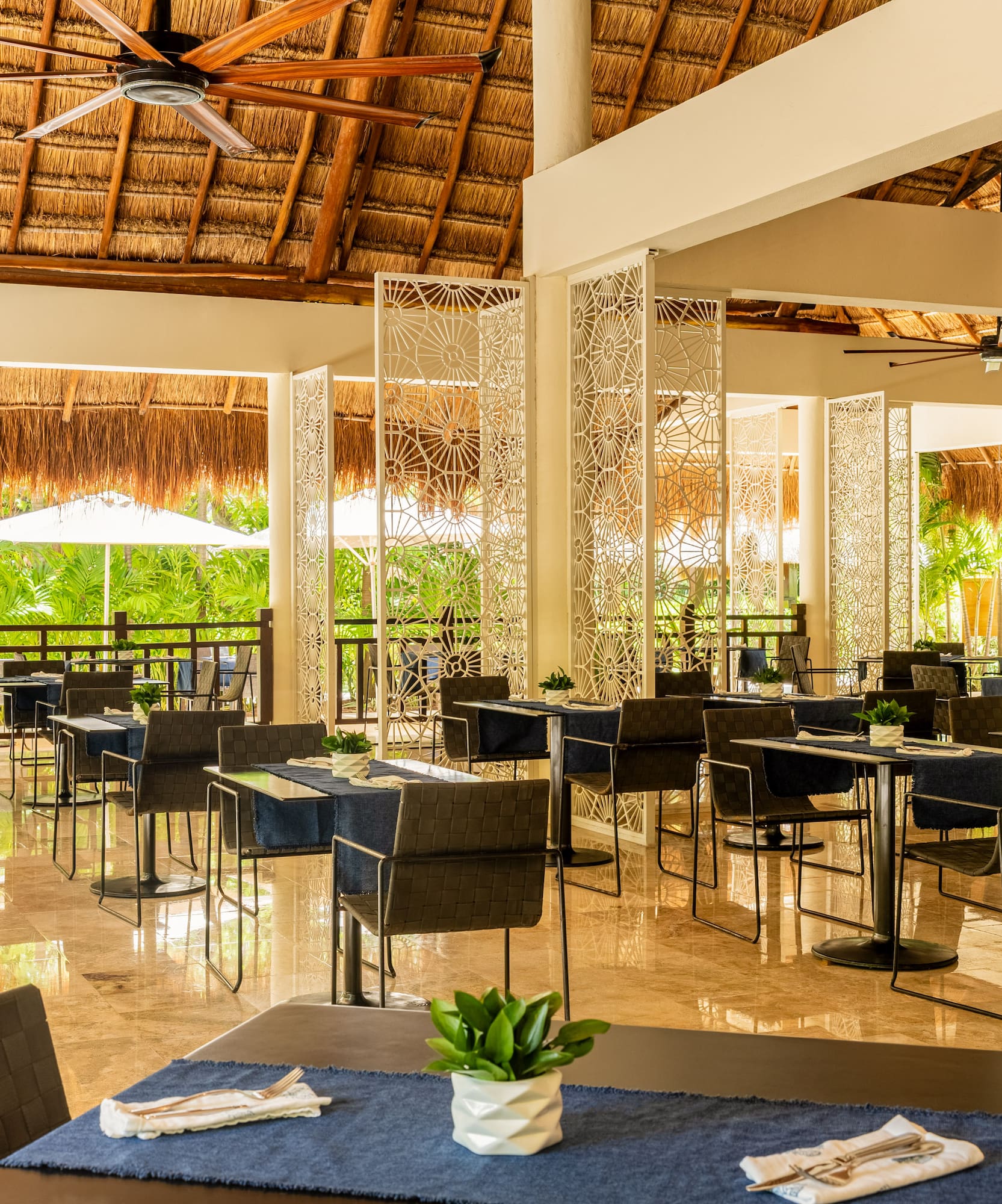 Tropical resort dining with palapa roof and decorative screens.
