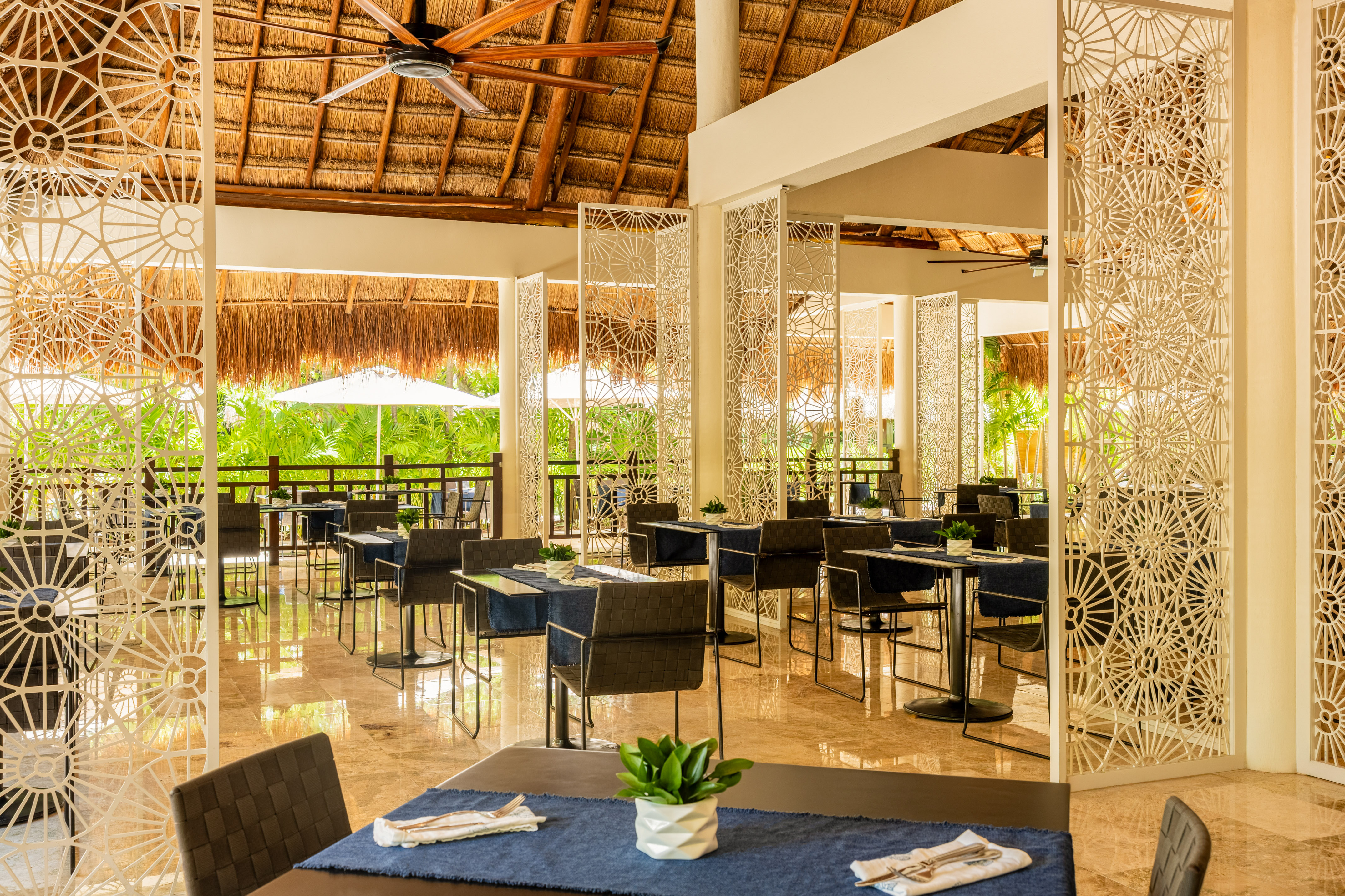Tropical resort dining with palapa roof and decorative screens.