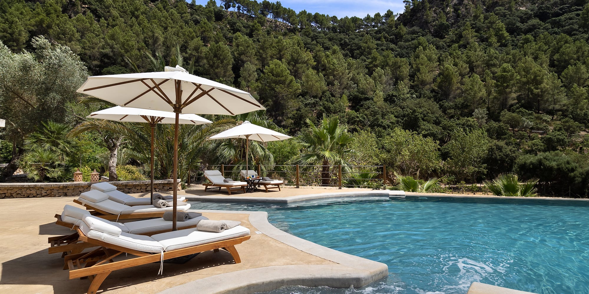 a pool with chairs and umbrellas by it