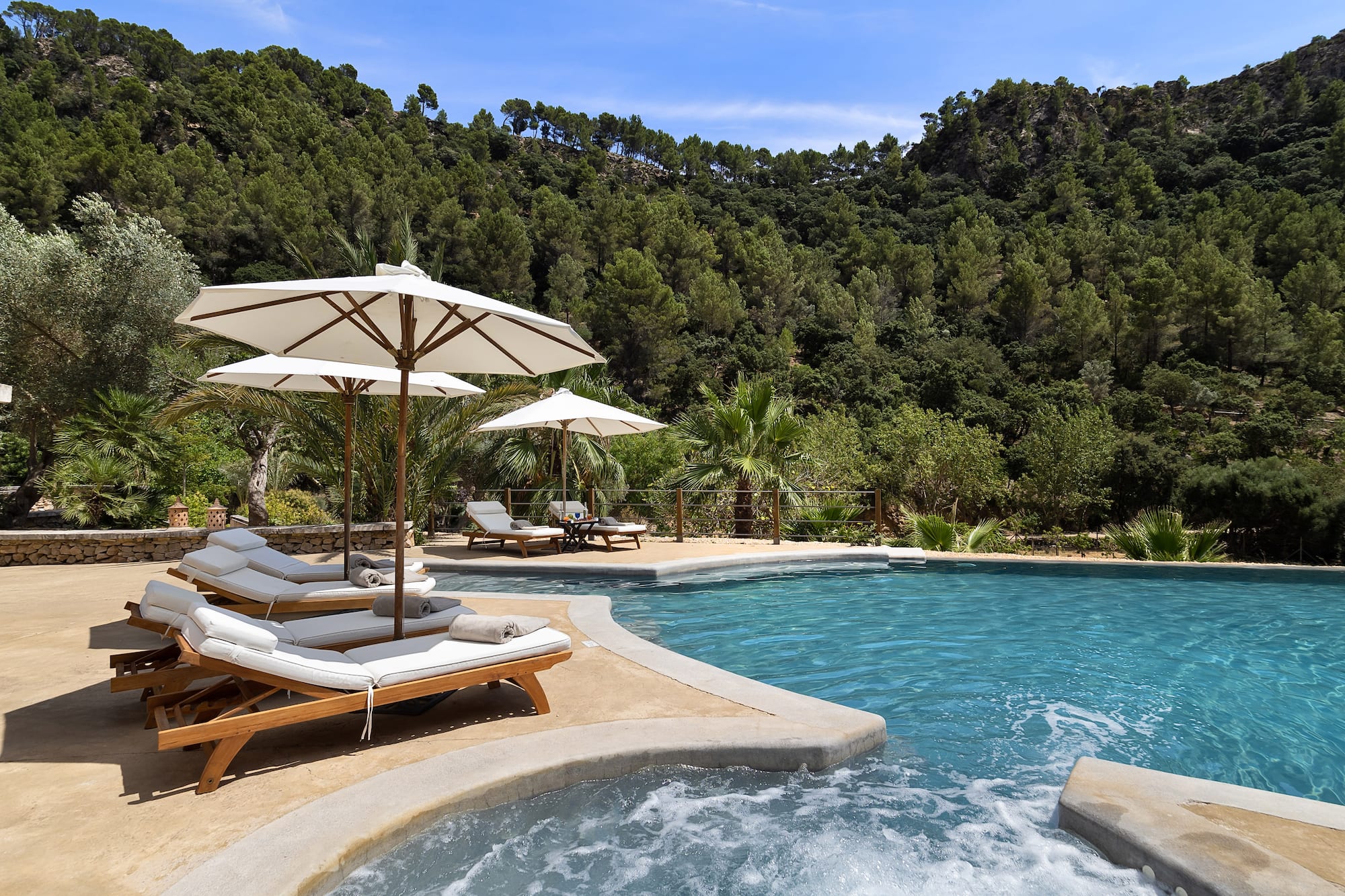 a pool with chairs and umbrellas by it