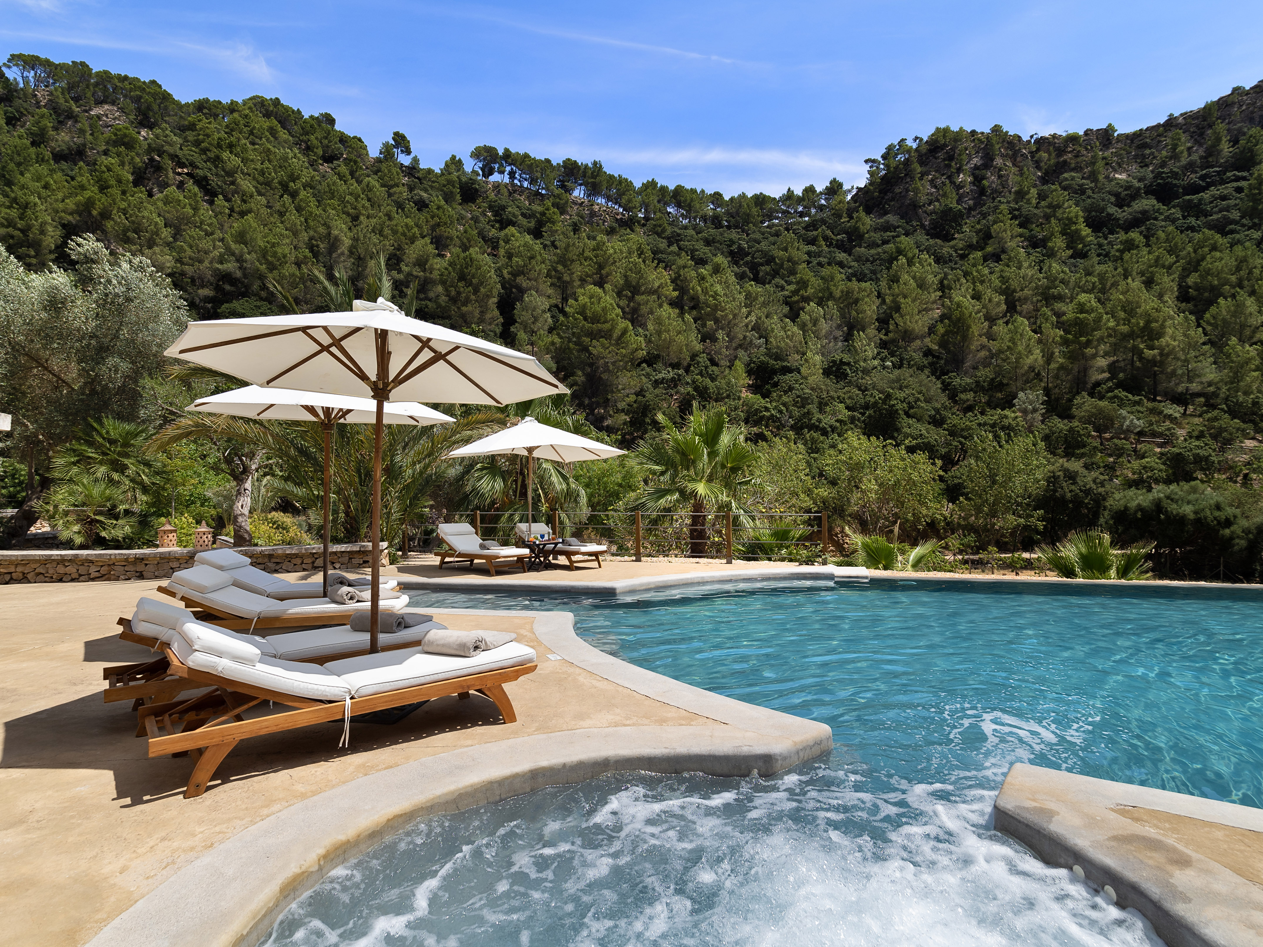 a swimming pool with sunbeds and sunshades