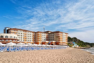 a beach with a large building and chairs