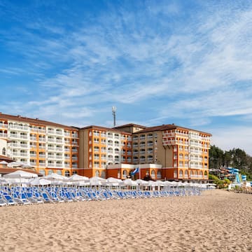 a beach with a large building and chairs