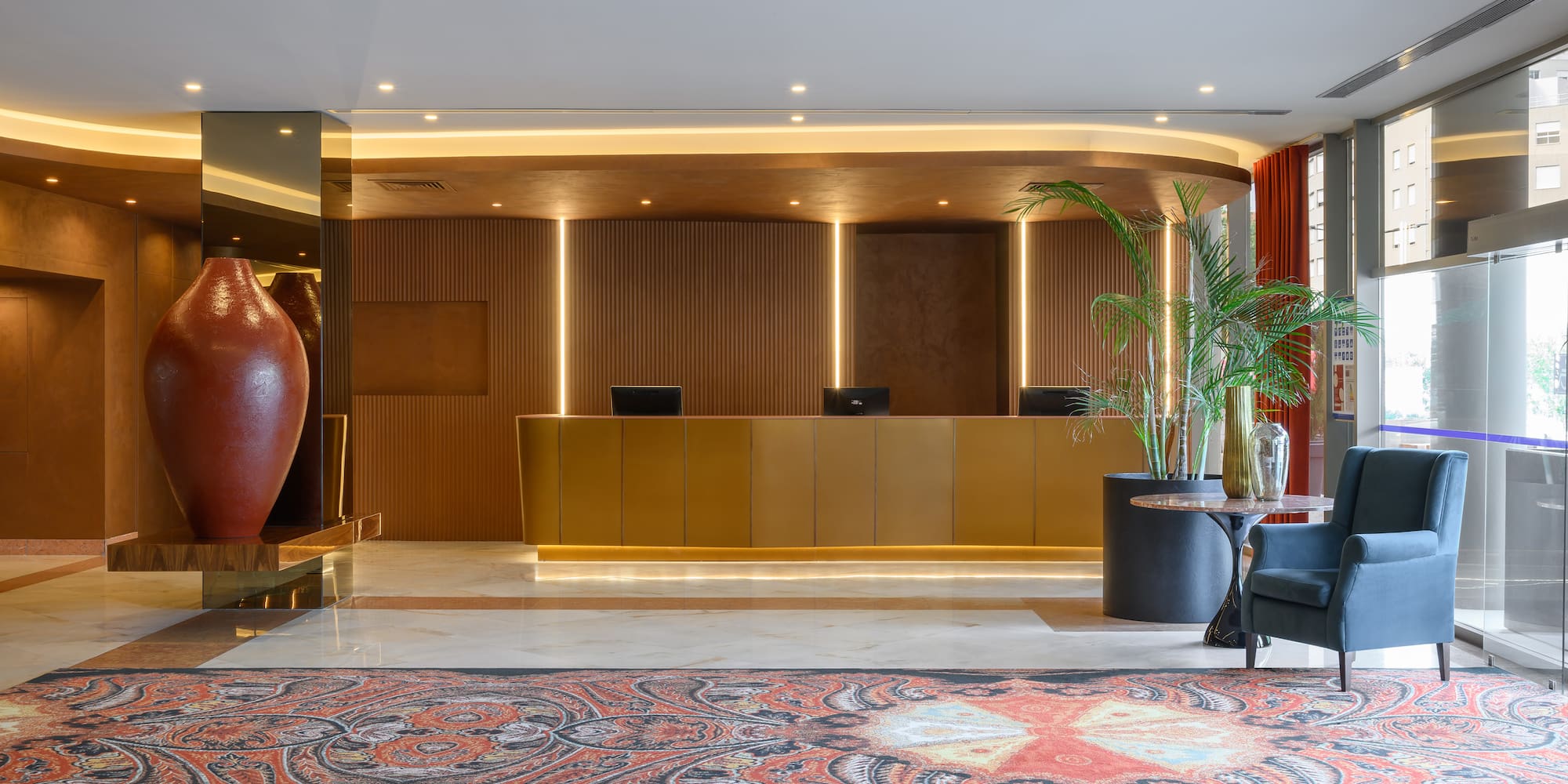 a lobby with a large vase and a plant