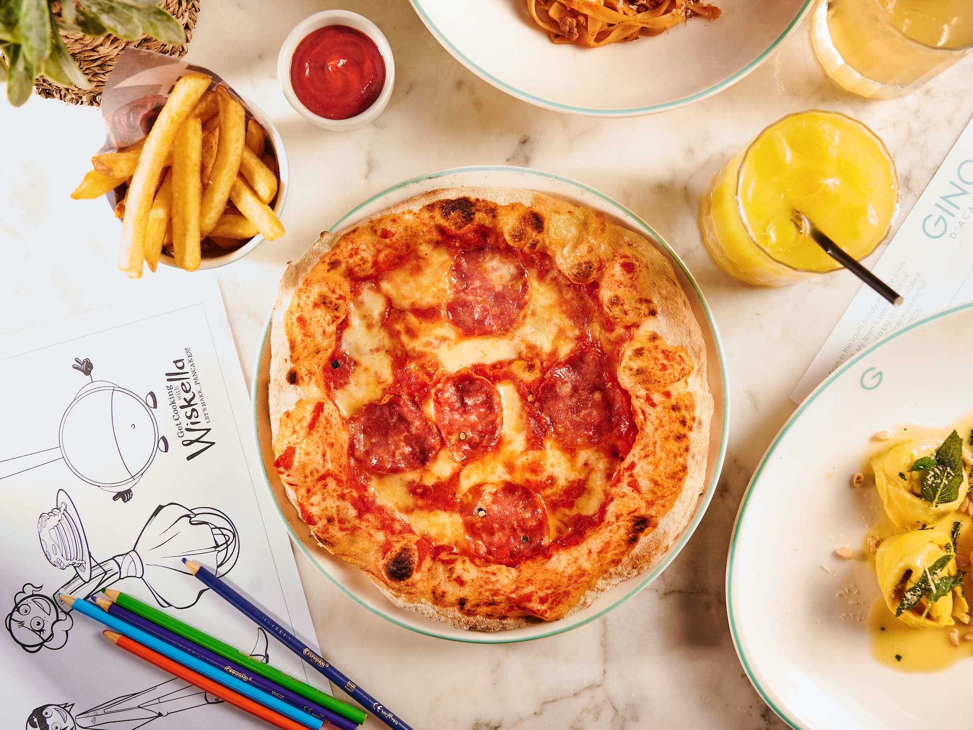 Kids' pepperoni pizza, fries, juice, and coloring sheet at an Italian restaurant.