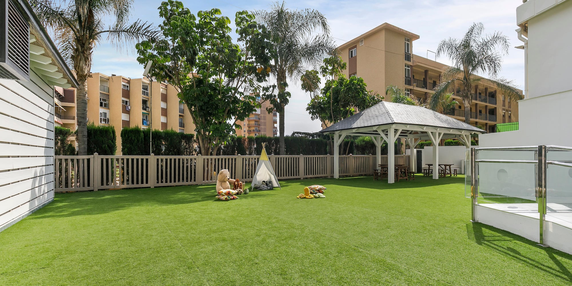 a playground with a white structure and trees