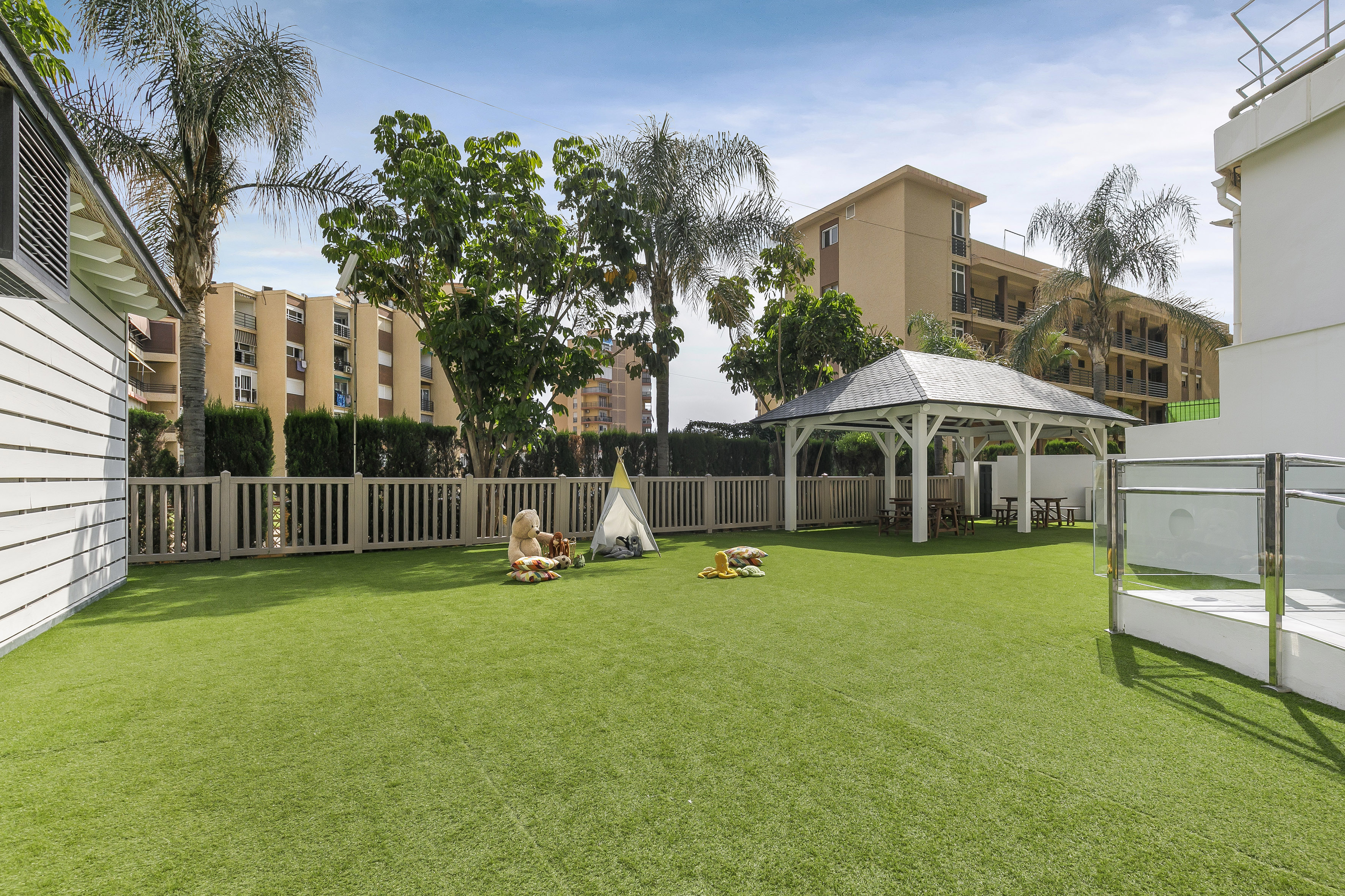 a playground with a white structure and trees