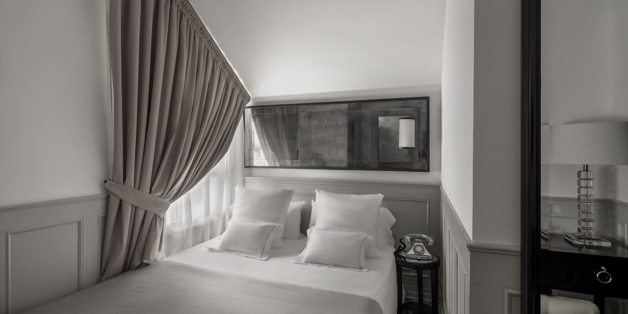 a bed with pillows and a mirror above it