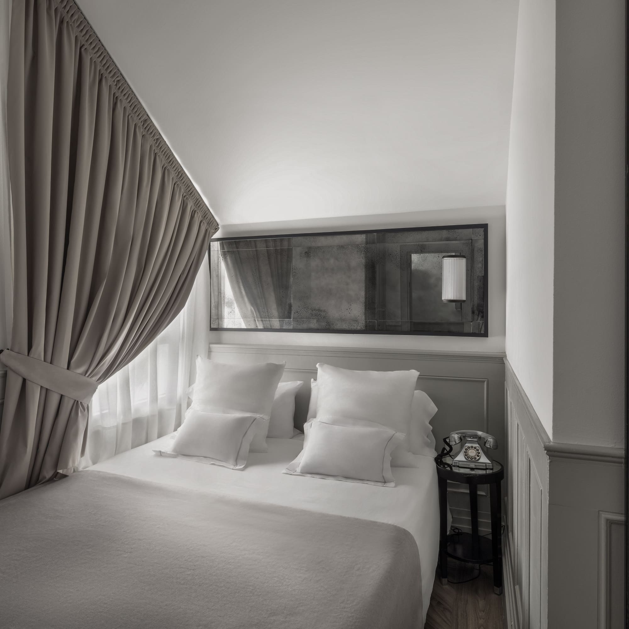 a bed with pillows and a mirror above it