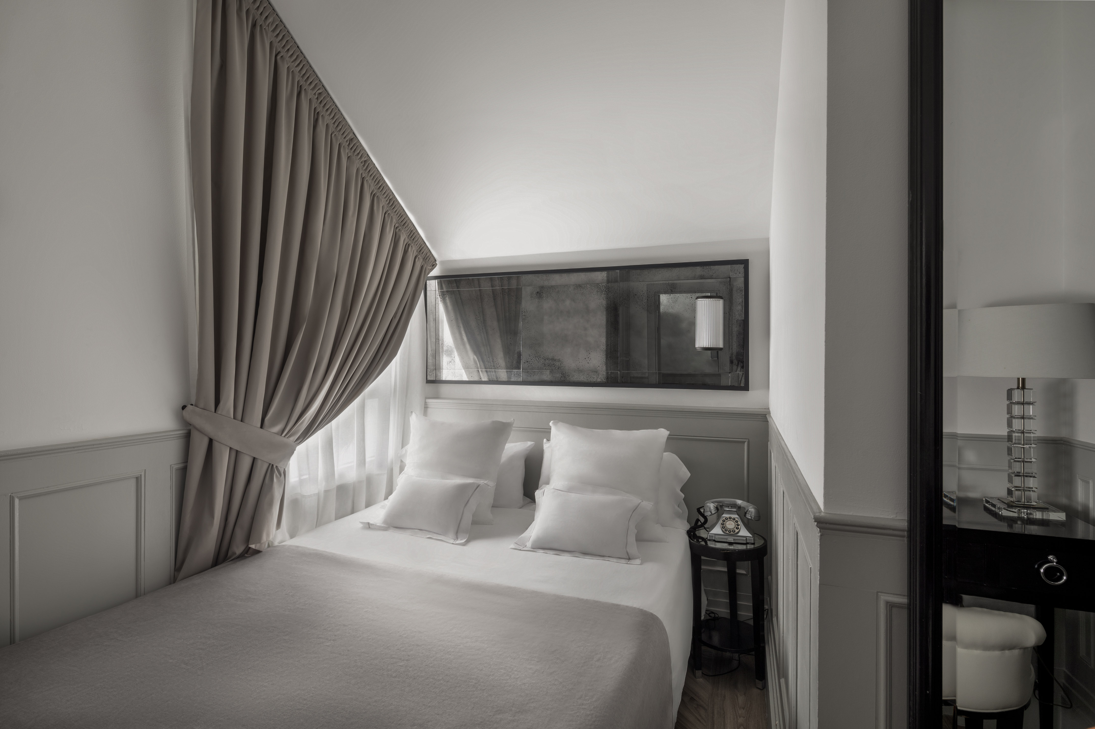 a bed with pillows and a mirror above it