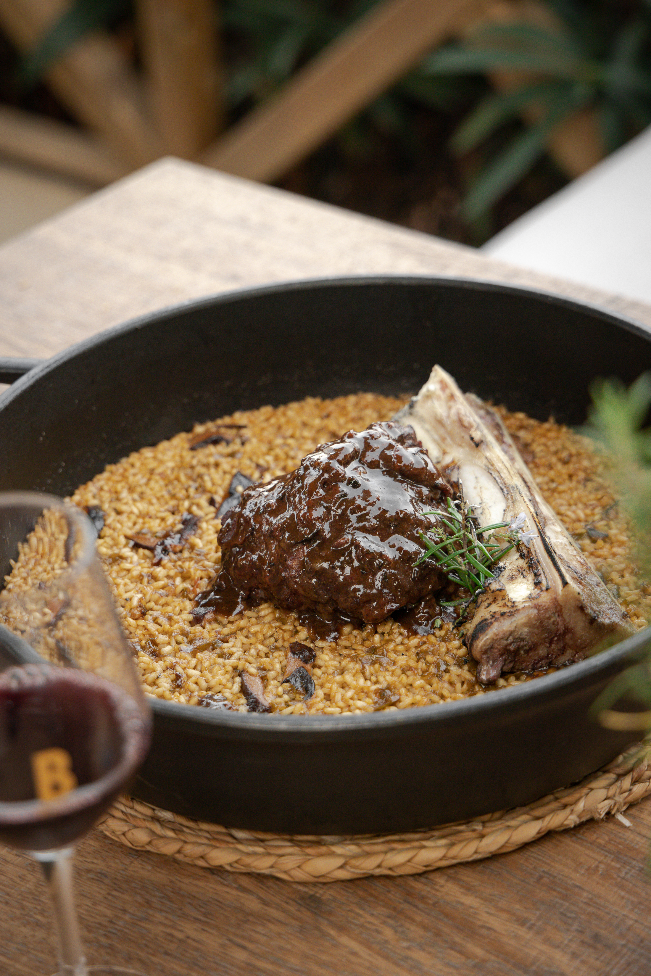 Braised short rib and bone marrow paella with rosemary in a cast iron pan.