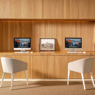 a desk with two computers and a picture frame on it