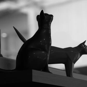 a black and white photo of a cat statue