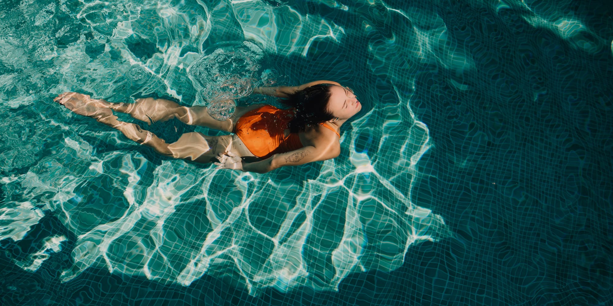 a woman in a swimsuit in a pool.