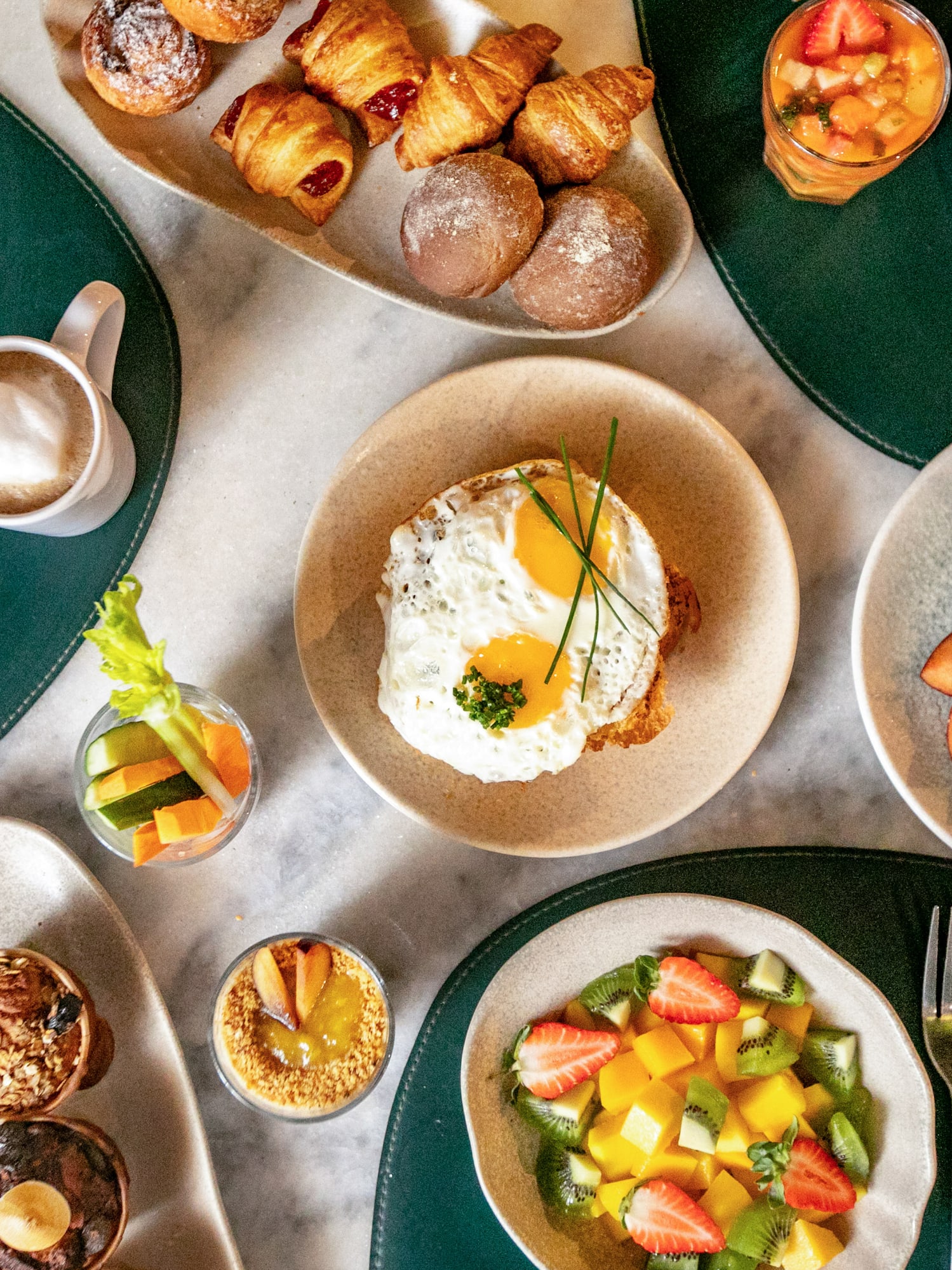 Bountiful breakfast spread: eggs, fresh fruit, pastries, coffee, and juices.