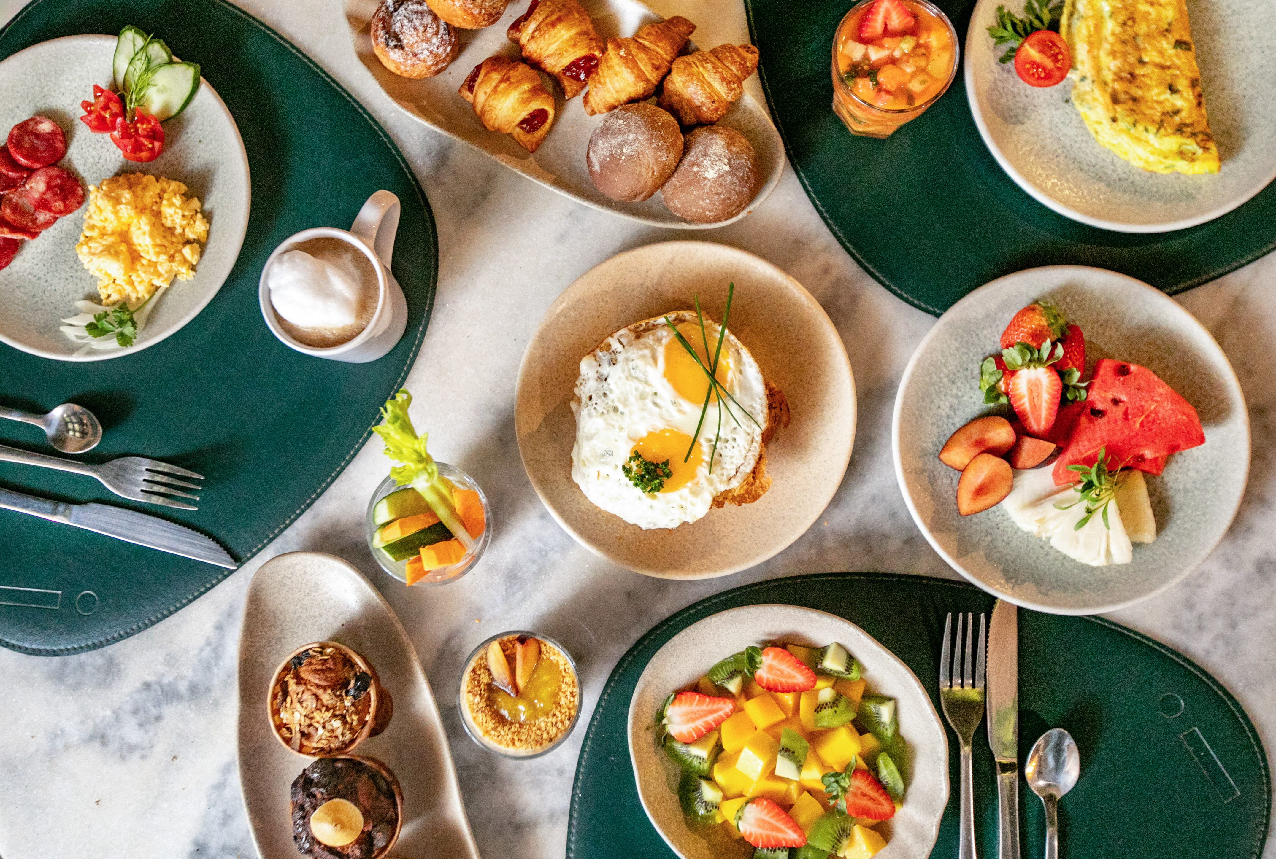 Bountiful breakfast spread: eggs, fresh fruit, pastries, coffee, and juices.
