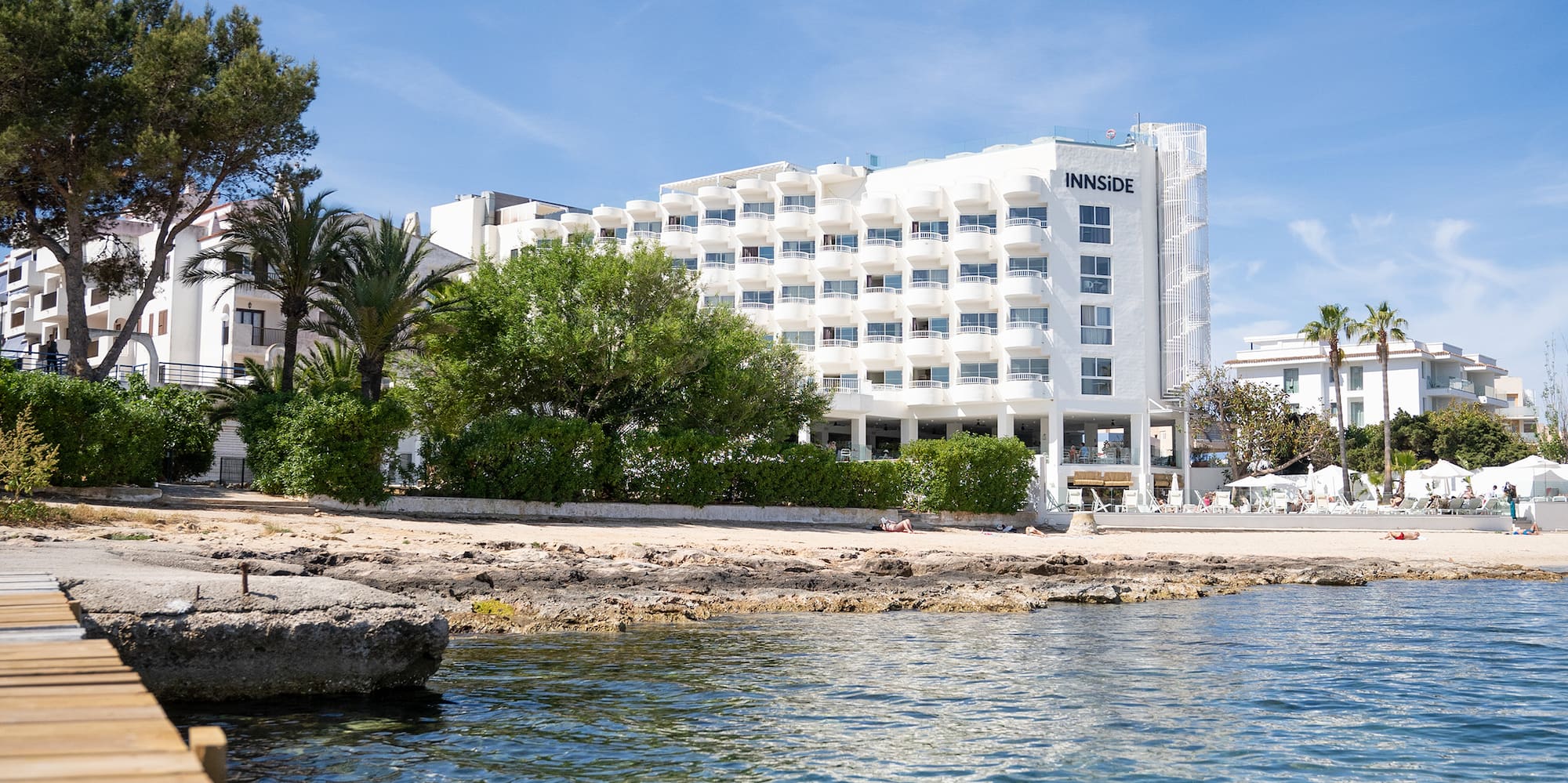a body of water with a dock and trees and buildings in the background