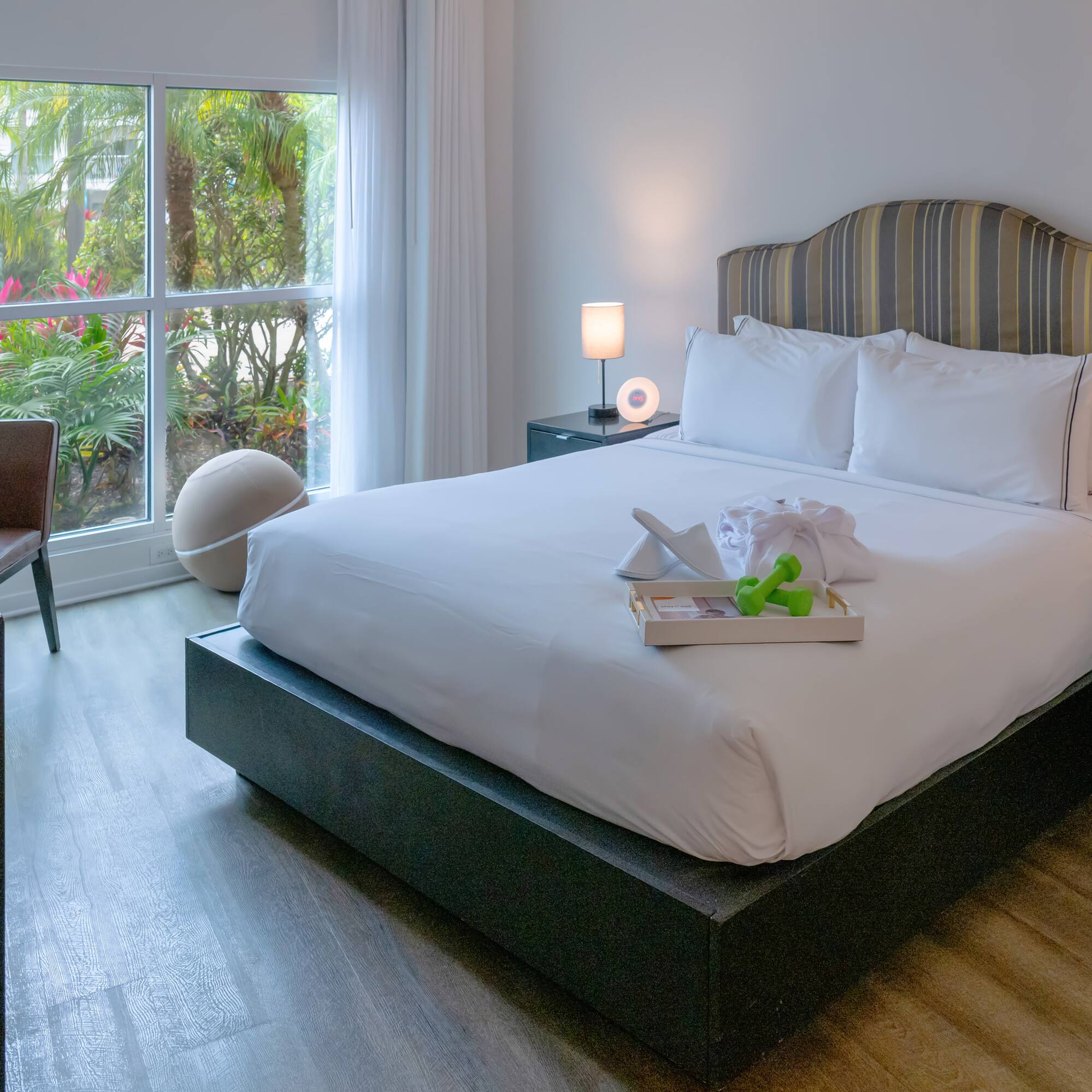 a bed with white sheets and a tray of toys on it